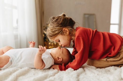 Geschwisterliebe: Kleines Mädchen und Baby 